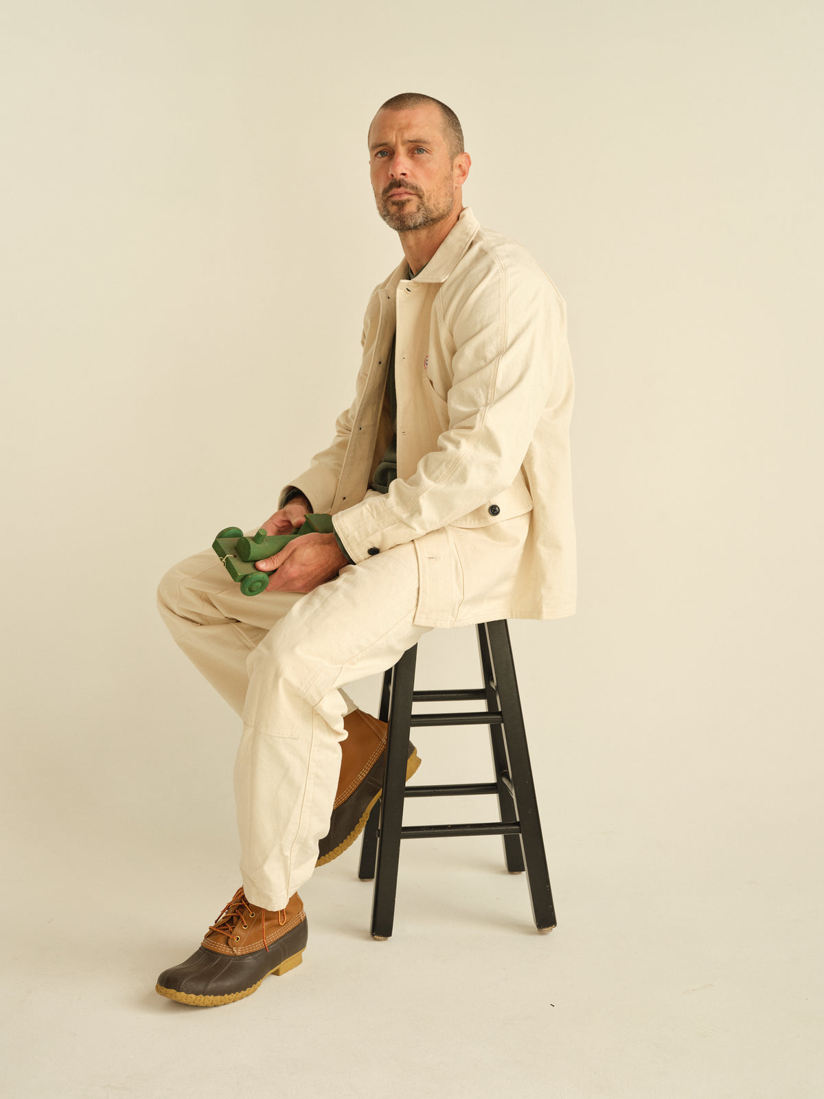Natural chore jacket on model, button front with pointed collar and flap chest pocket