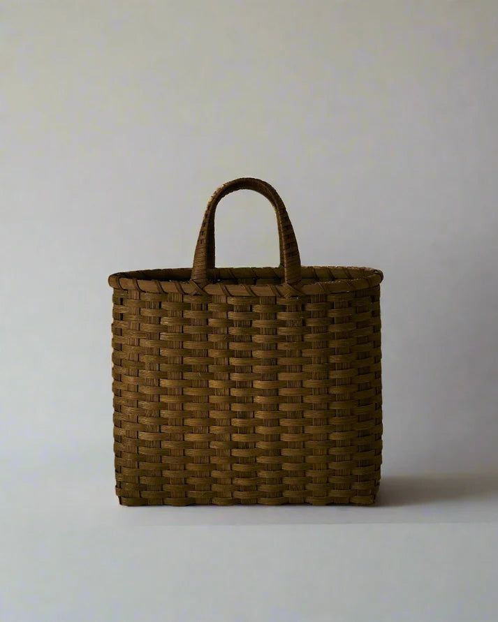 Woven shopping basket with short dark-brown handles and open top