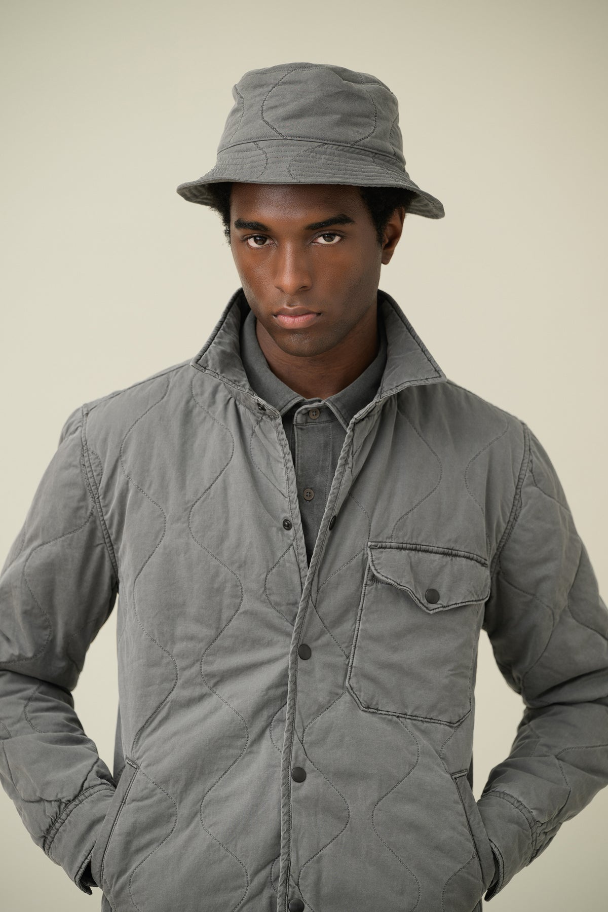 Quilted shirt jacket in gray with button front, stand collar, and chest pocket