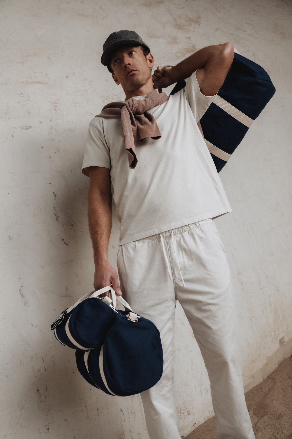 Navy school boy duffel bag with white-striped straps and top zipper compartment