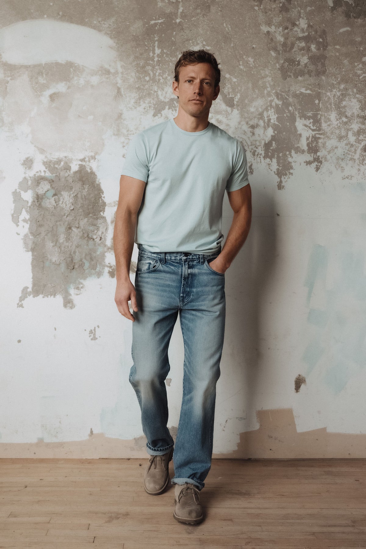 Men's vintage-wash blue jeans worn with a light crew-neck T-shirt