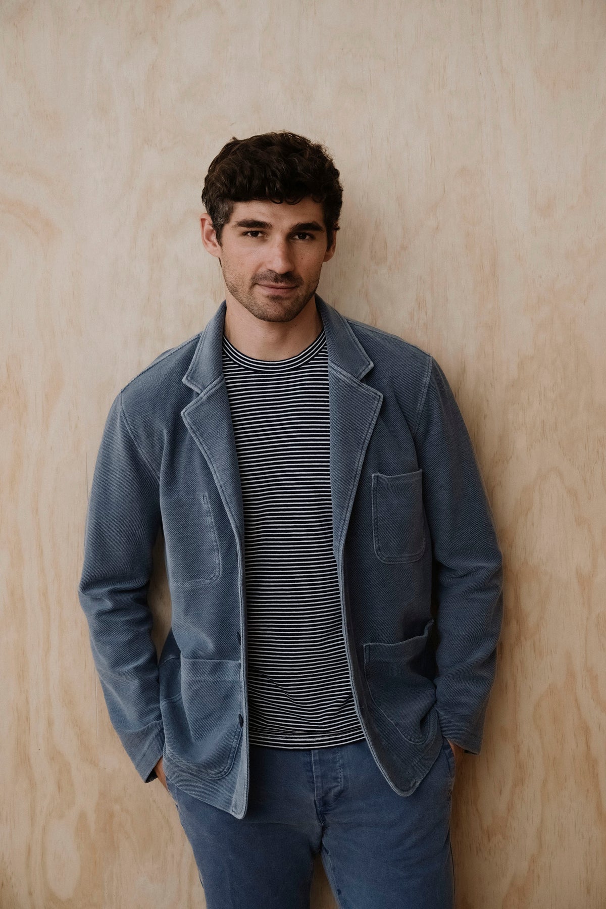 Twill terry blazer in union blue with notched lapels and button front, worn with striped shirt.