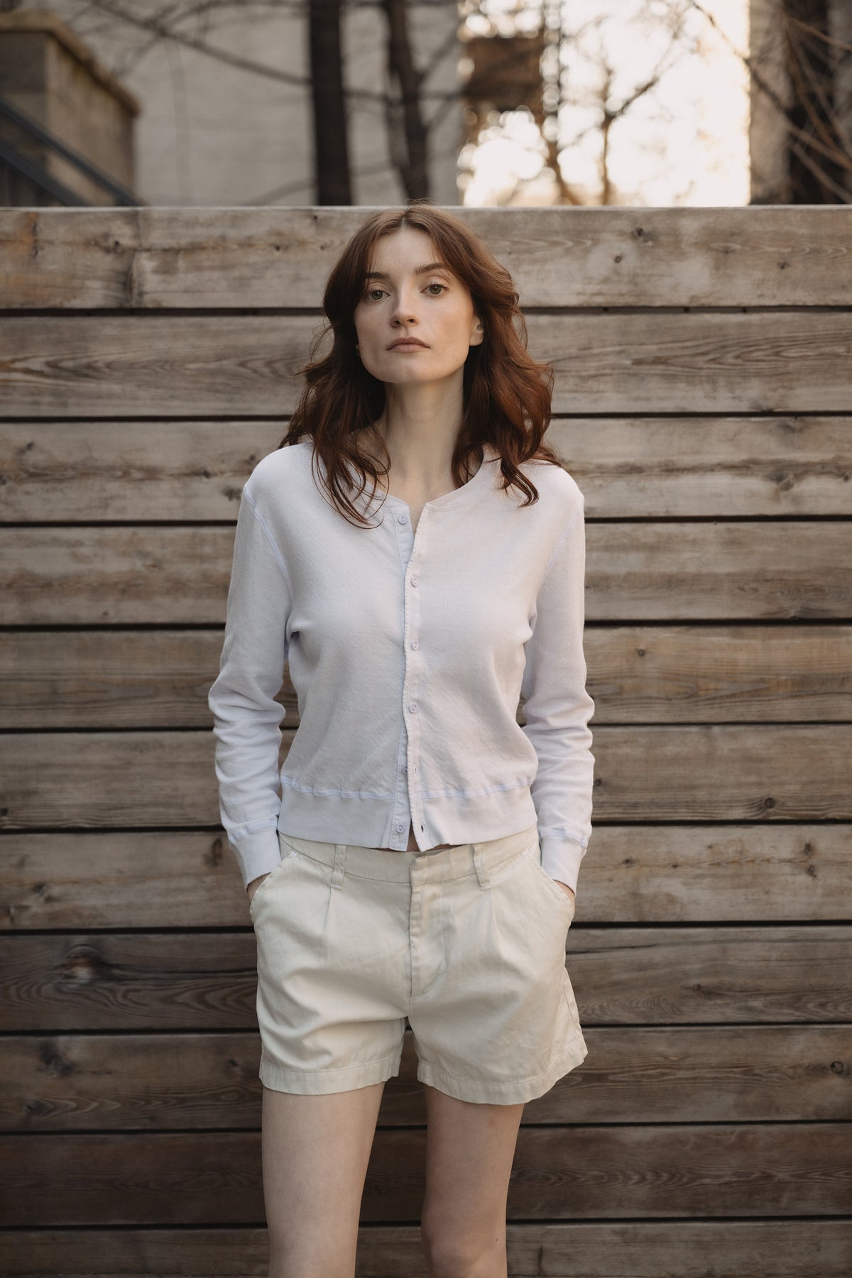 Cream pleated twill shorts on a model, showing front and side pockets