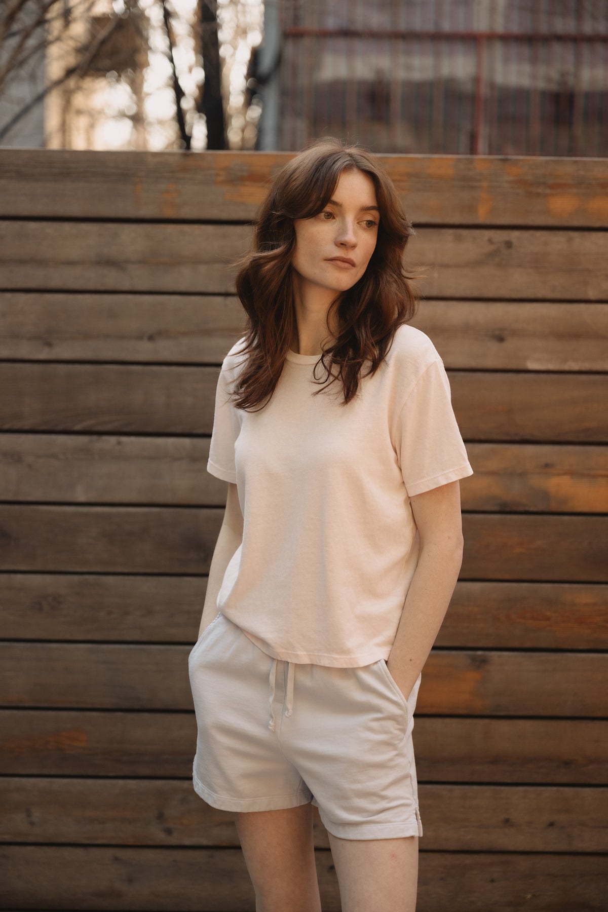 White sweat shorts with elastic waistband, drawstring, and side pockets on model