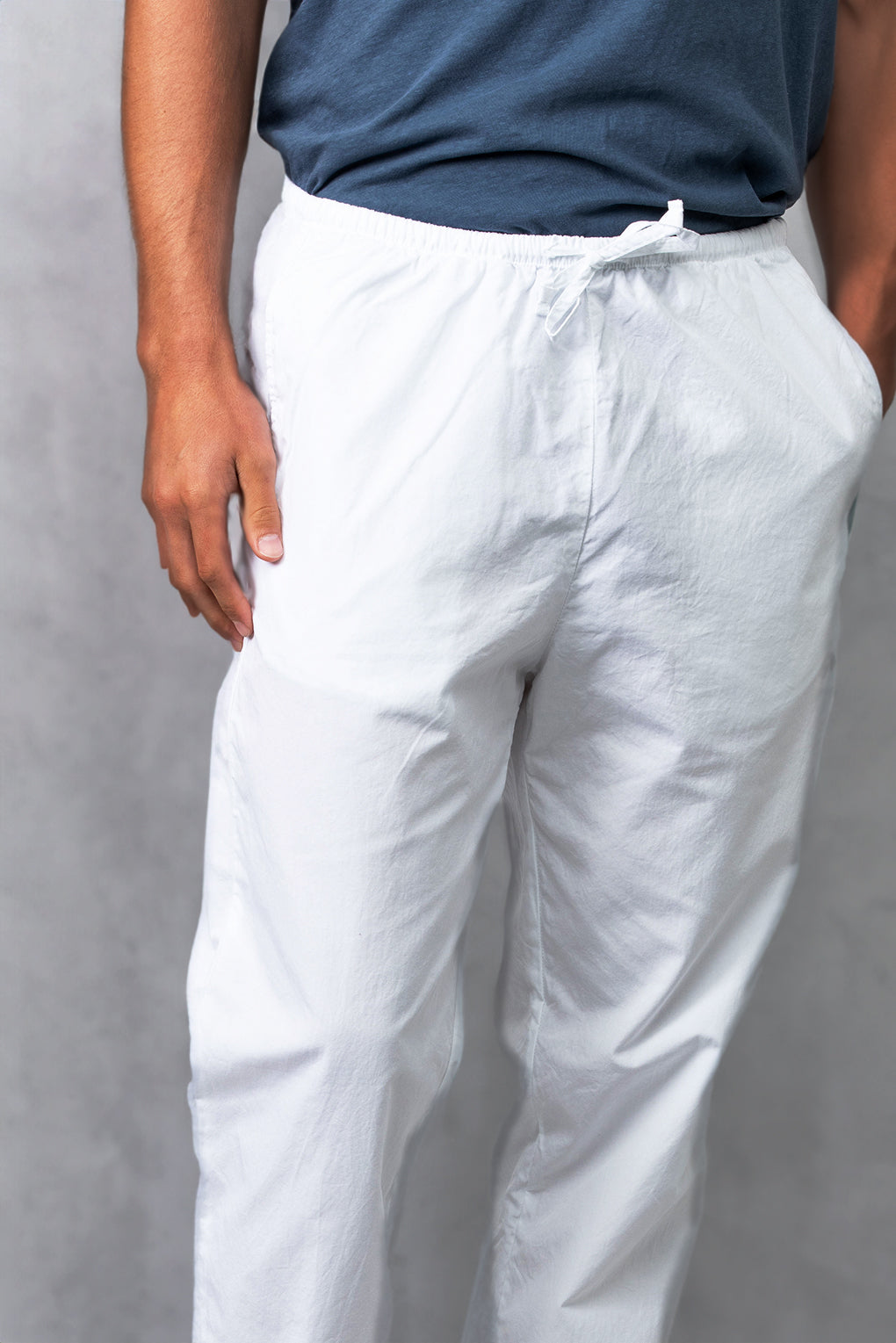 White poplin drawstring pants with elastic waist and tapered straight legs