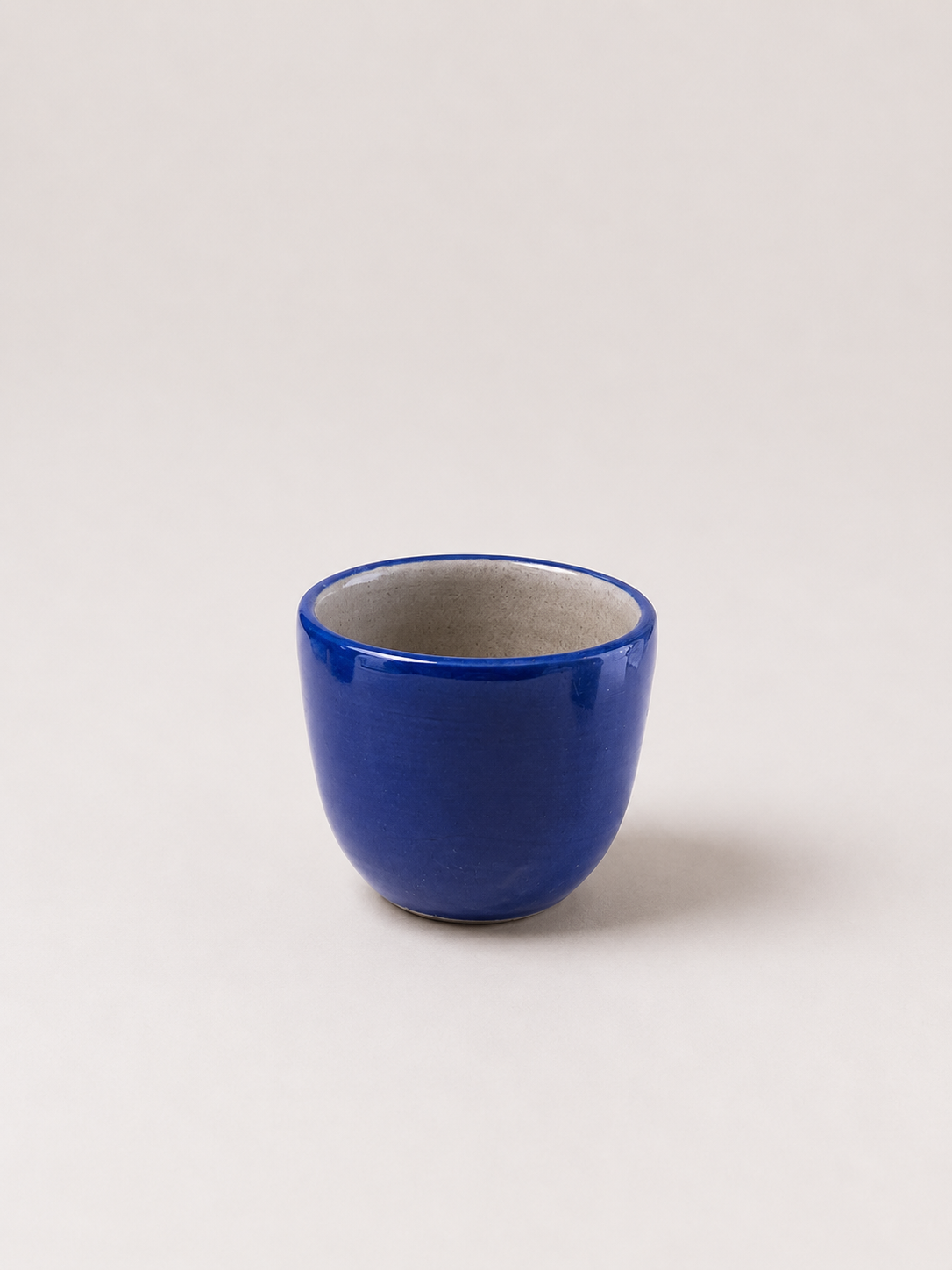 Blue ceramic coffee cup with glossy finish and wide, rounded rim