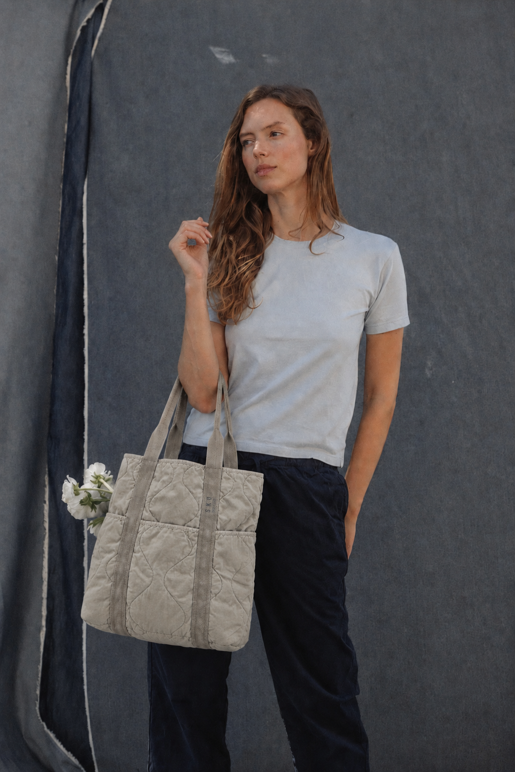 Quilted khaki tote bag with top handles and vertical stitched seams