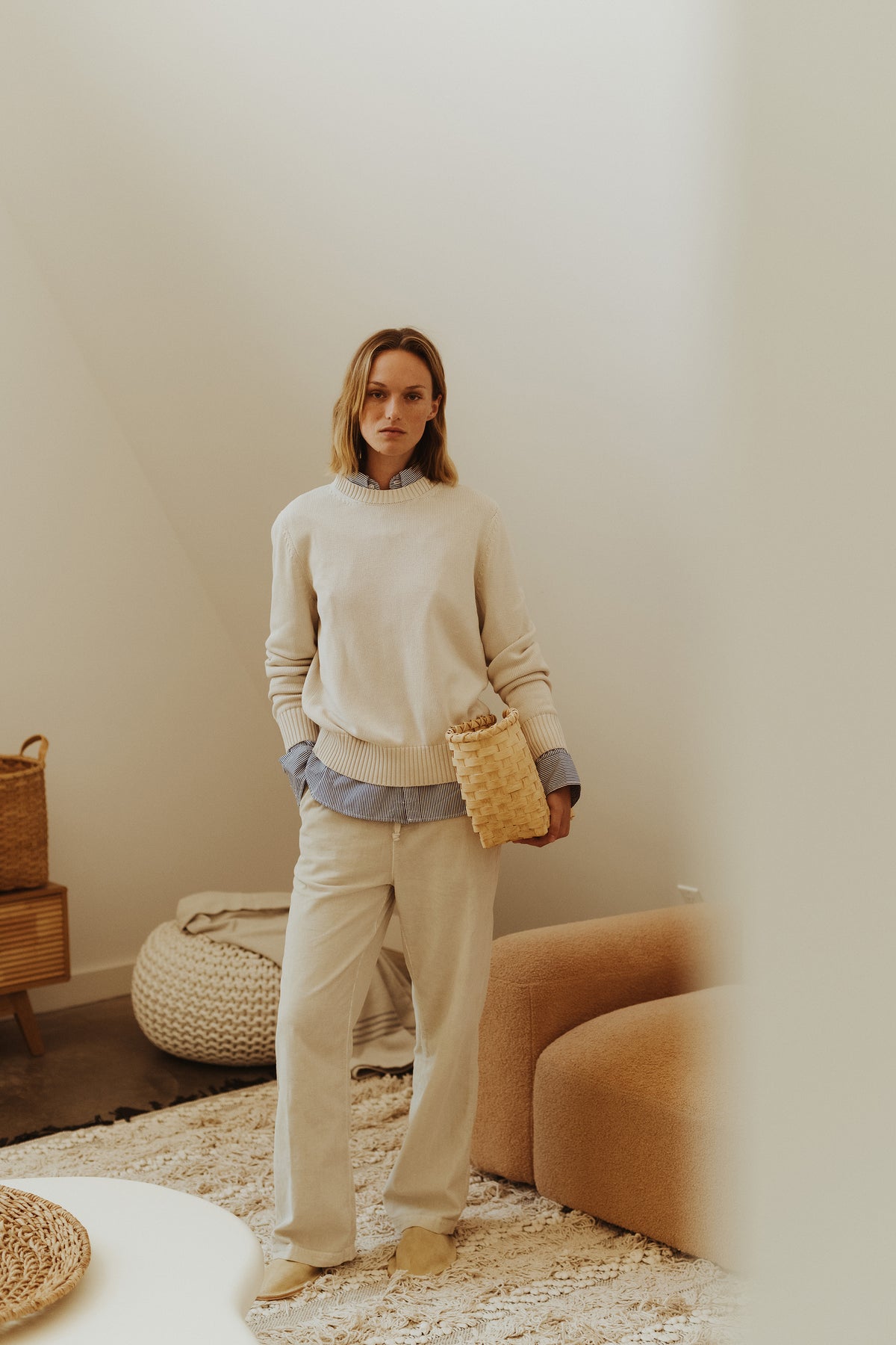 Cream knit sweater and matching pants outfit on model with striped collar detail.