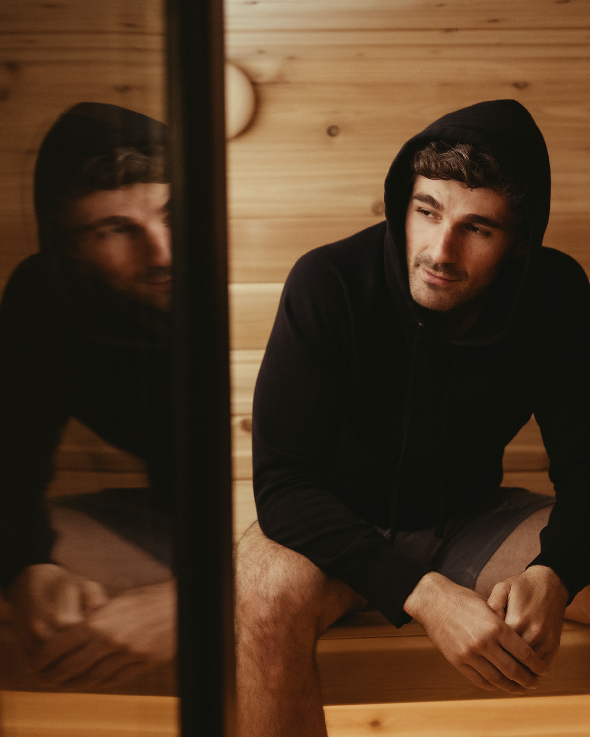 Black pullover hoodie with drawstring hood worn by a man in a hoodie