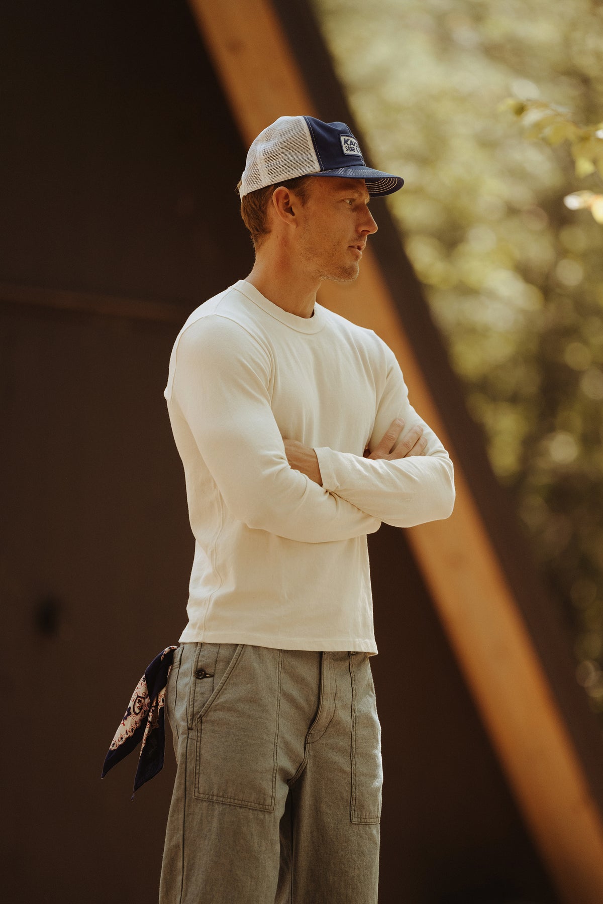 White long-sleeve layer tee worn by a man, side view with crew neck visible