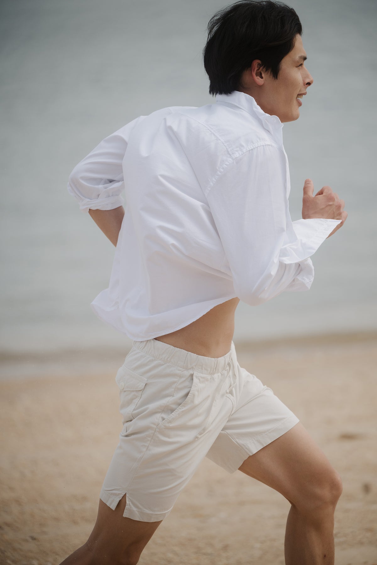 White poplin button-up shirt worn, with spread collar and long sleeves.