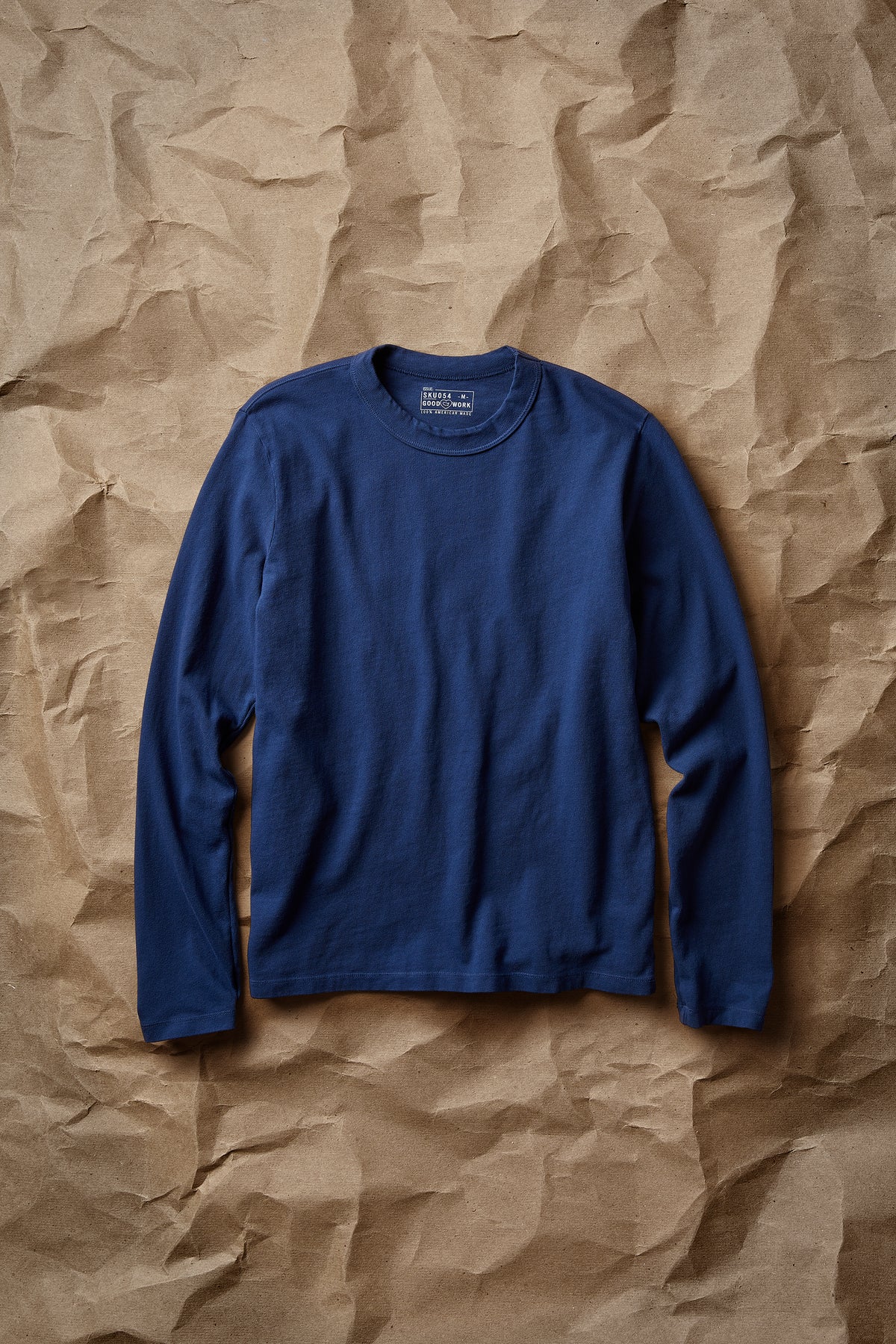 Blue long-sleeve layer tee with crew neck and ribbed collar, laid flat front view