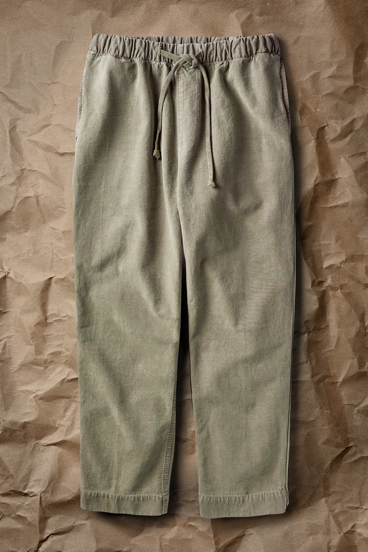 Modern worker pants in olive green, elastic waistband with drawstring, wide straight legs.