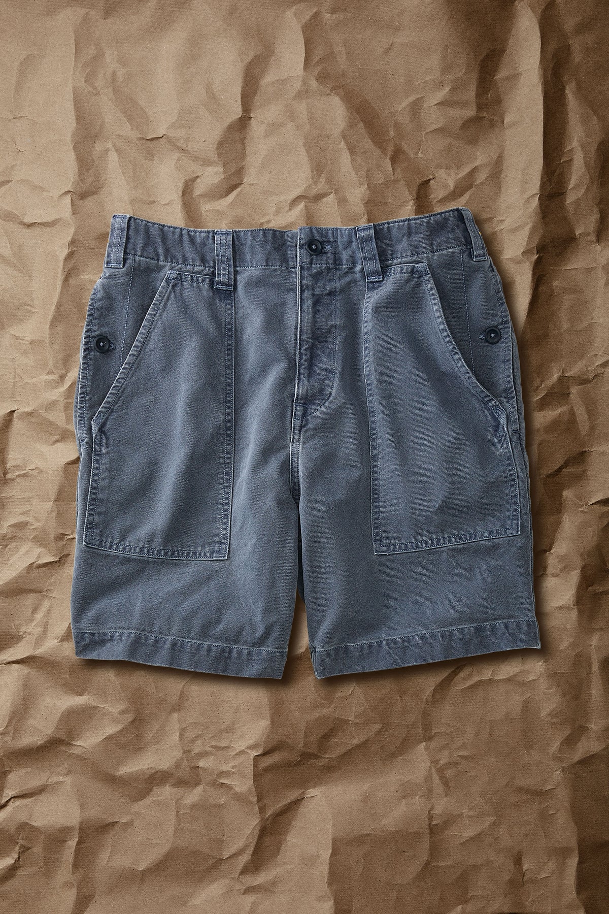 Faded navy cotton drill shorts, mid-thigh length, cargo pockets, button fly