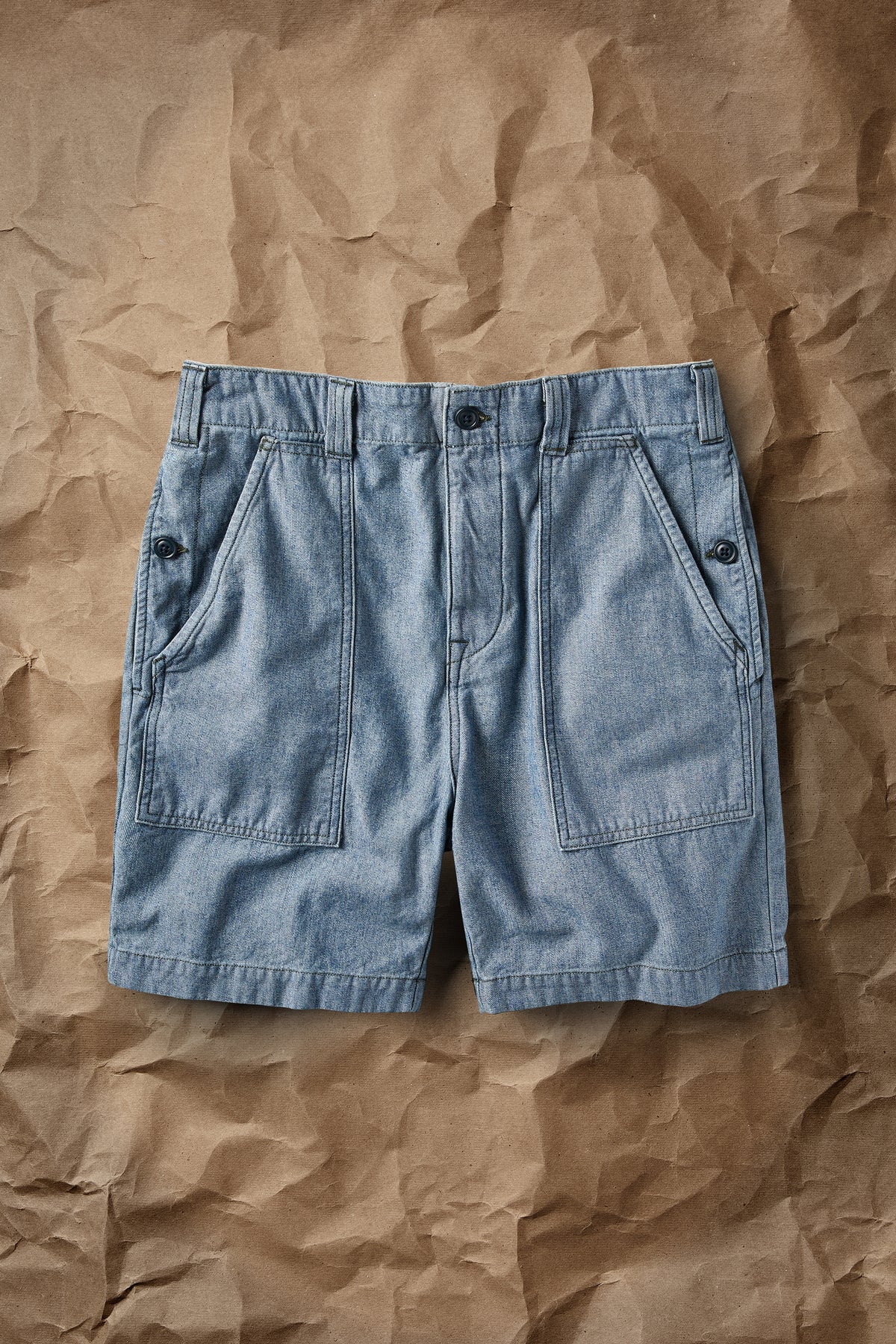 Light blue denim shorts back view with flap pockets and button closure