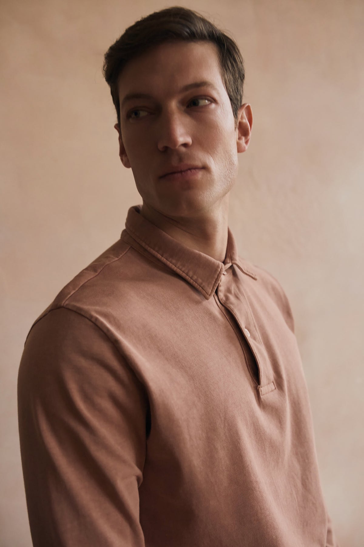 Dusty rose polo shirt close-up with pointed collar and short button placket