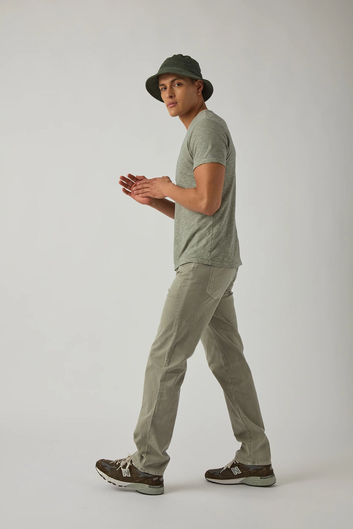 Model wearing khaki standard jeans with straight leg and button fly