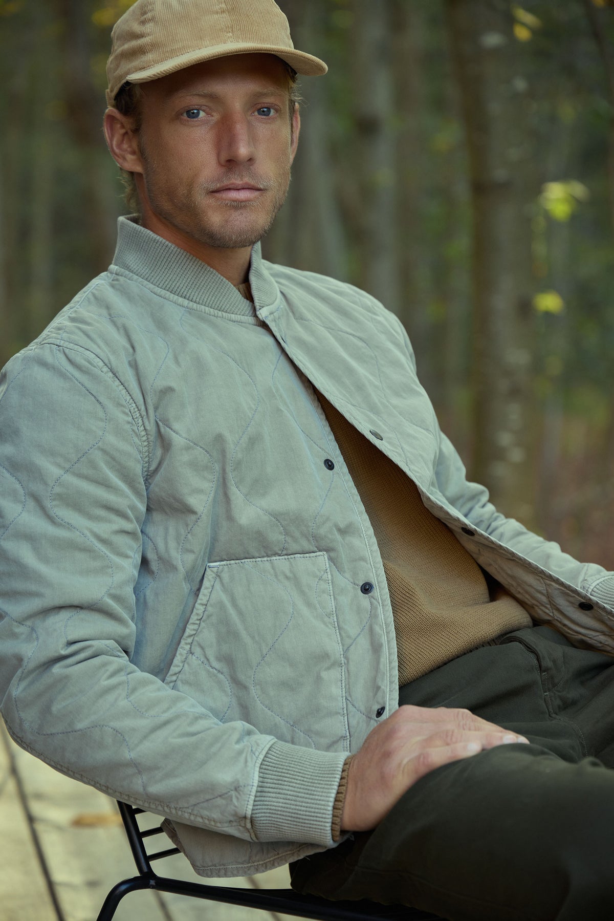 Quilted bomber jacket in light green worn by a model outdoors