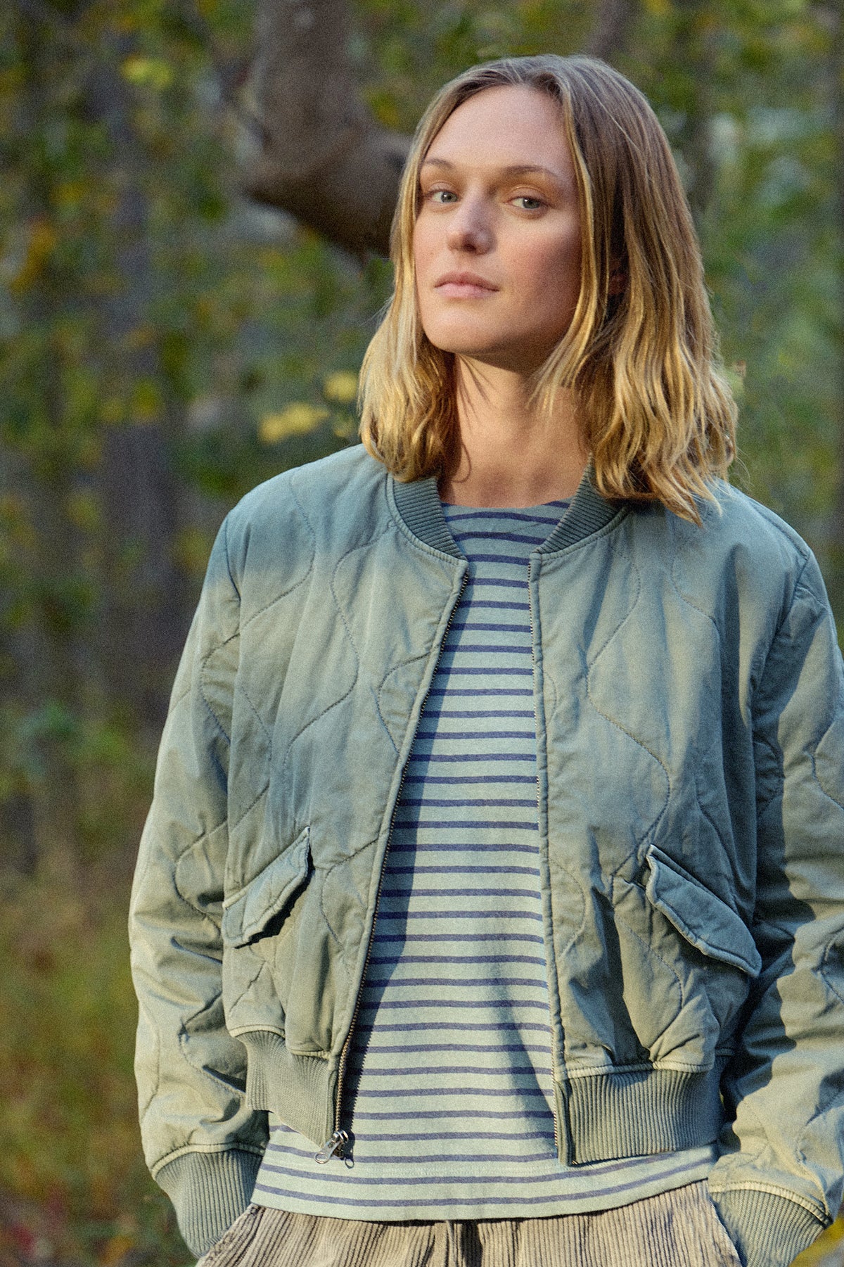 Blue zip bomber jacket with ribbed collar, cuffs, waistband, and flap pockets