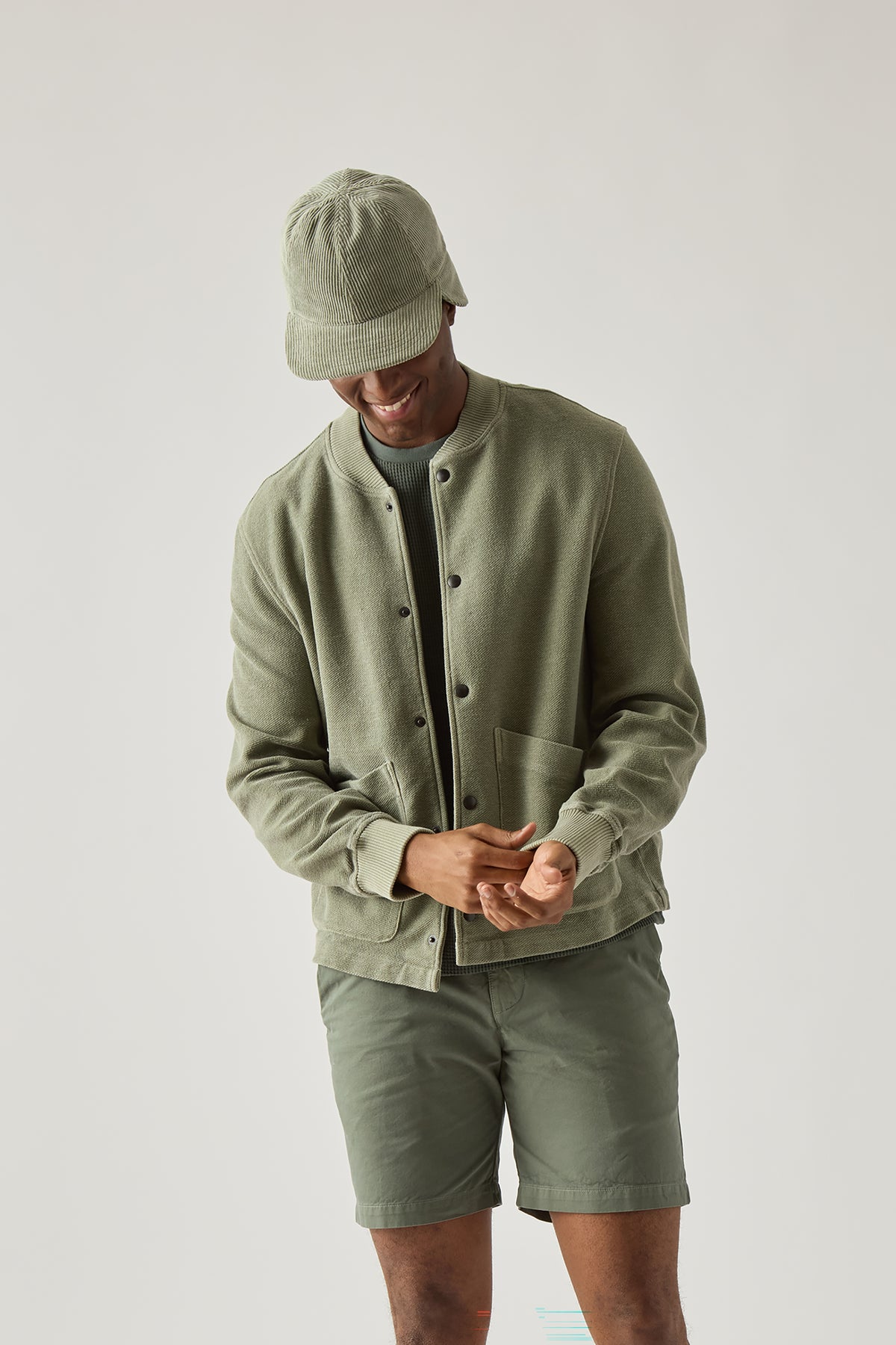 Olive warm-up jacket on model with button front and ribbed cuffs