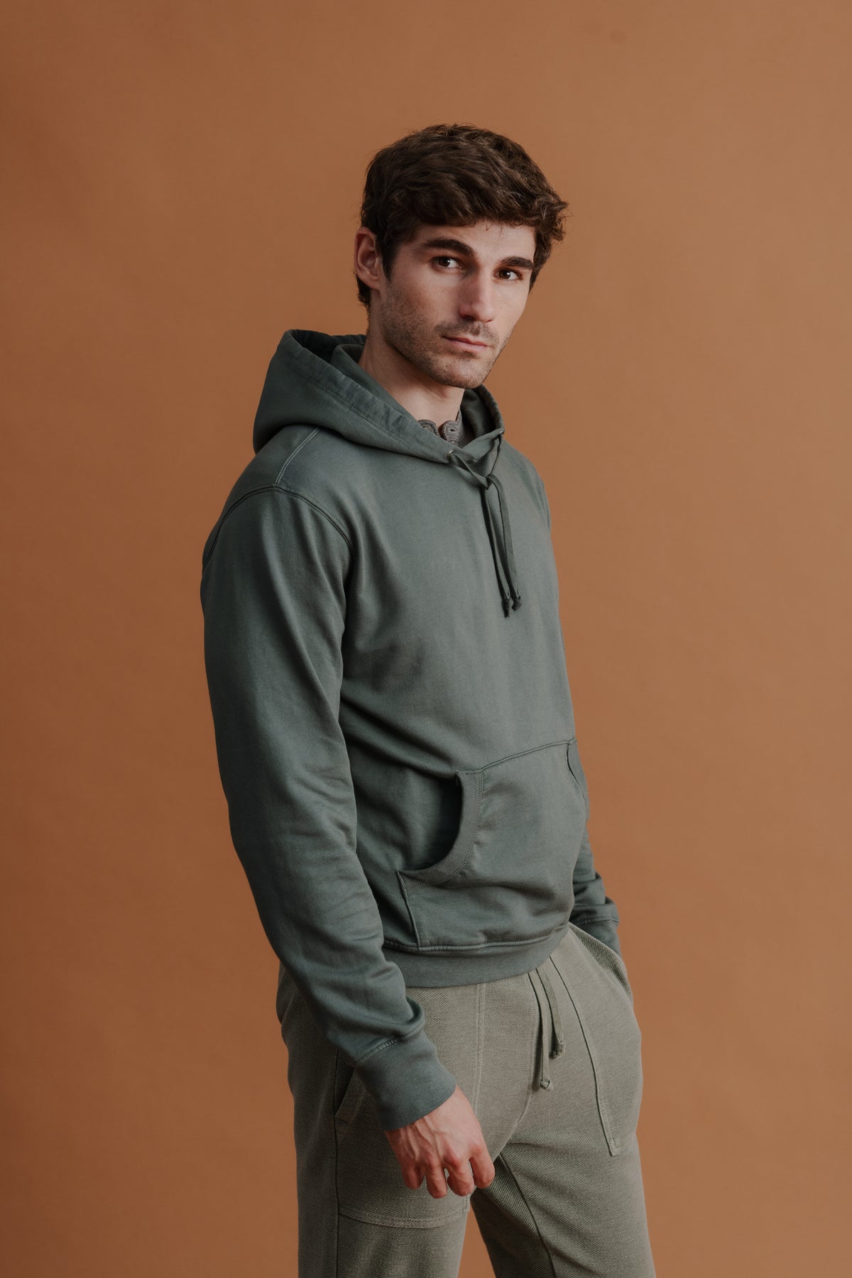 Green hooded pullover sweatshirt with drawstring hood and front kangaroo pocket