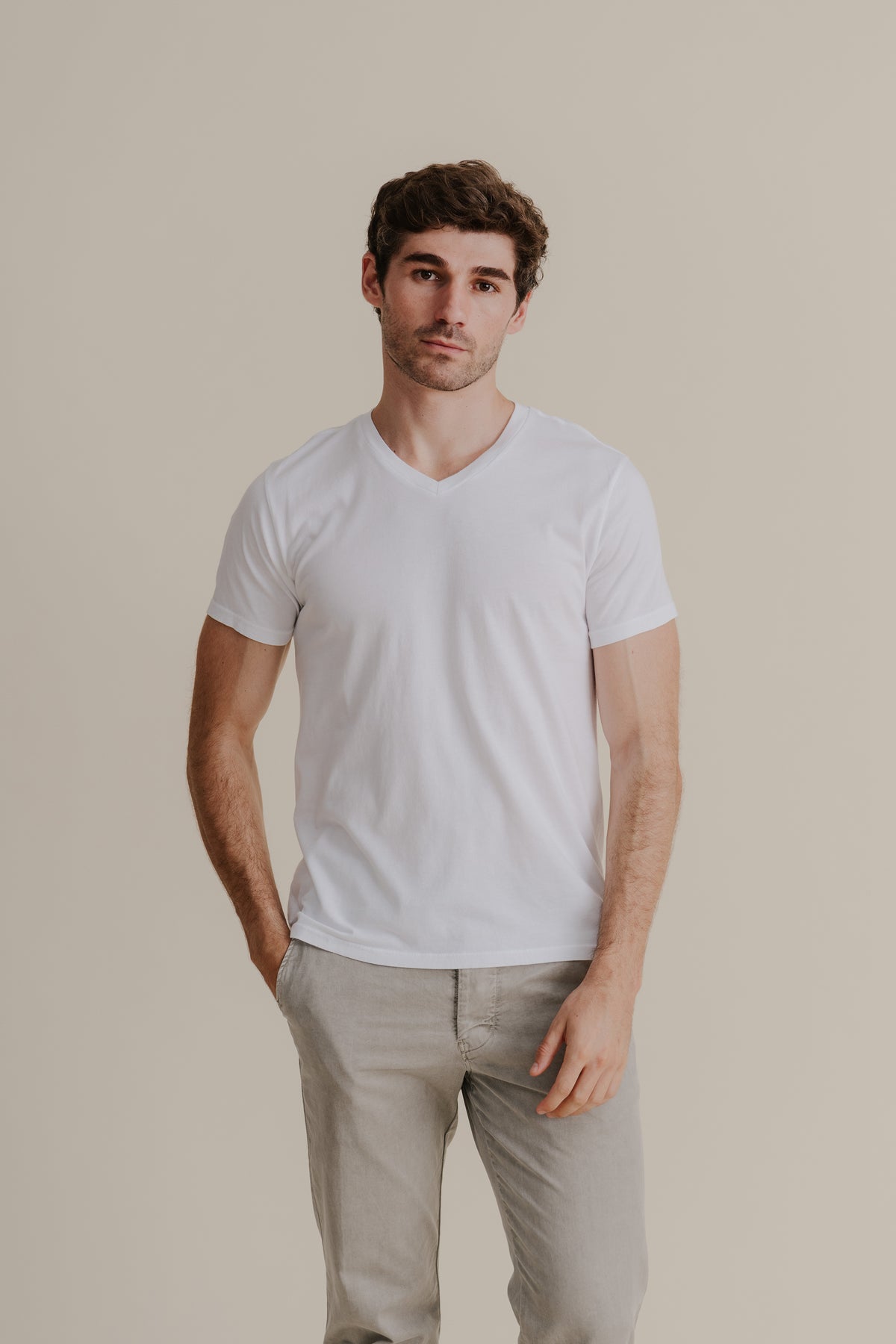 Men's white V-neck Supima tee worn by a model, short sleeves.
