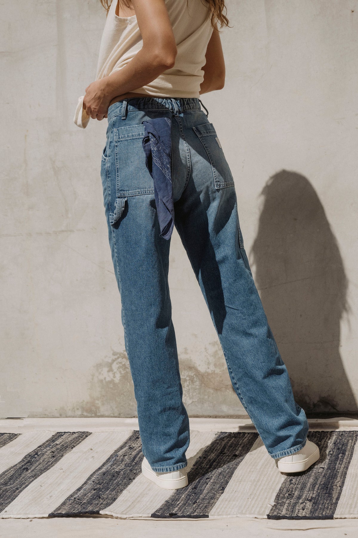 Painter dungaree in light blue denim with adjustable waist and patch pockets