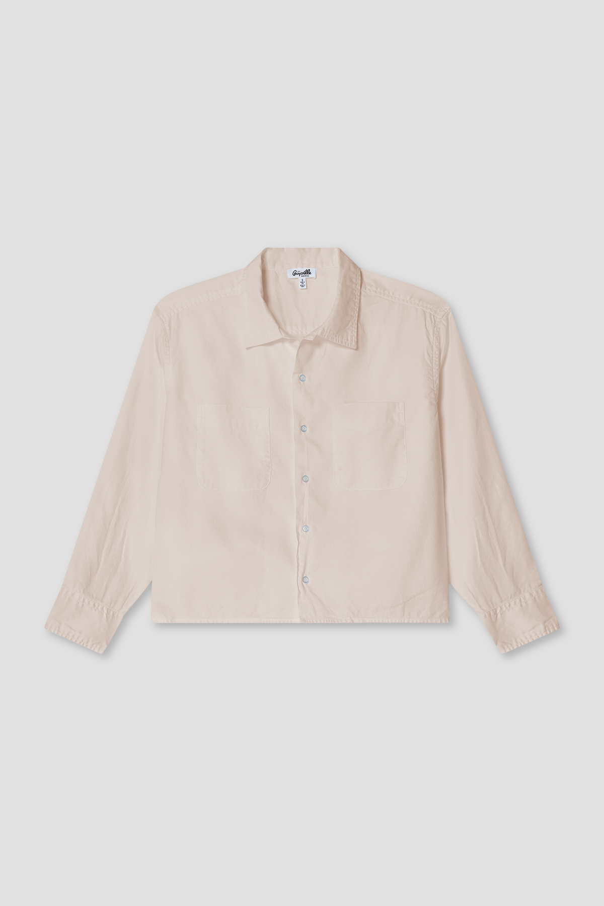 Light beige boxy oxford button-up shirt with spread collar, long sleeves, and chest pockets.