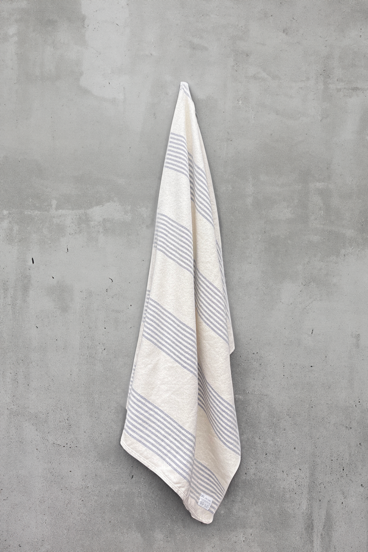 Striped oat blanket hanging with light-blue horizontal lines and neatly hemmed edge