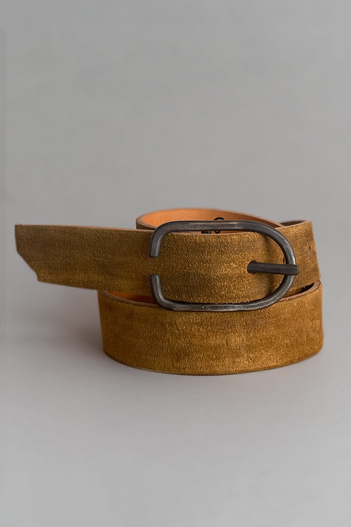 Tan suede-like belt with oval silver buckle