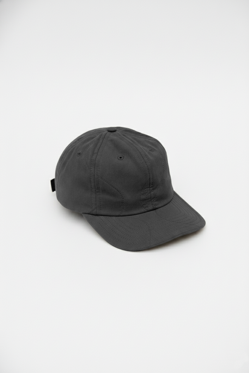 Quilted baseball hat in black with curved brim and eyelet ventilation
