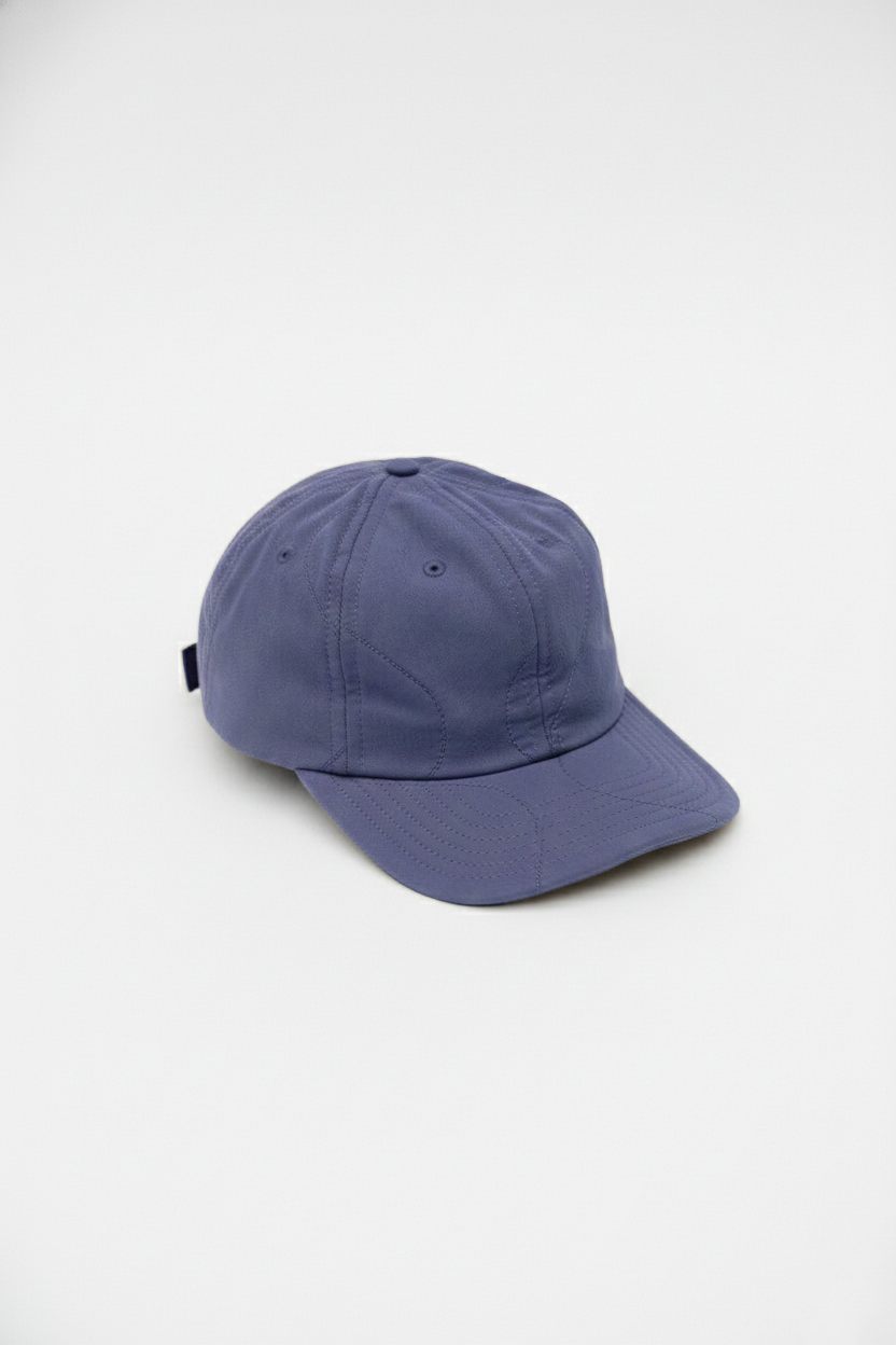 Quilted baseball hat in blue with curved brim and vent eyelets