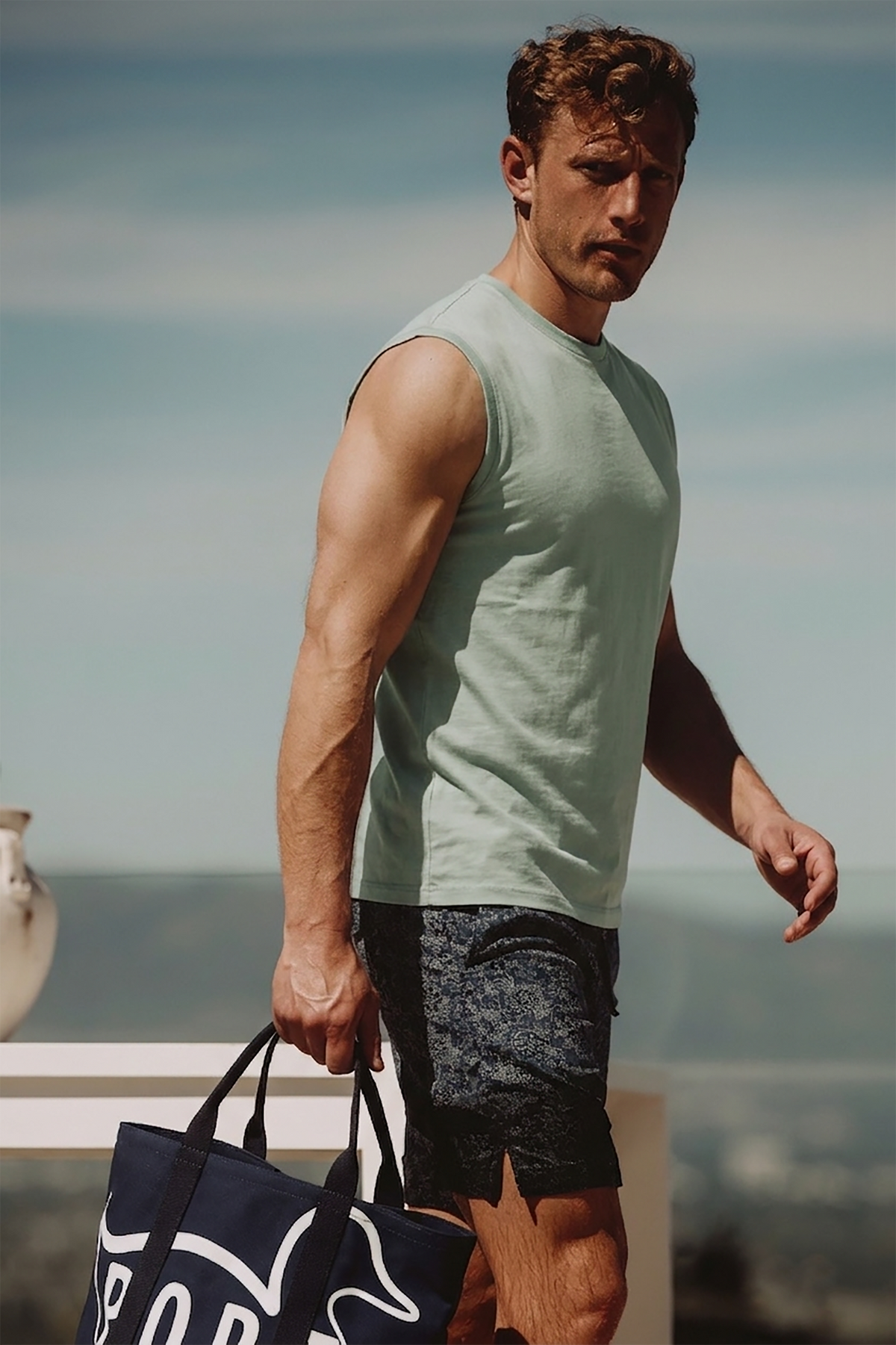 Light green sleeveless muscle tee on model, crew neck and wide armholes