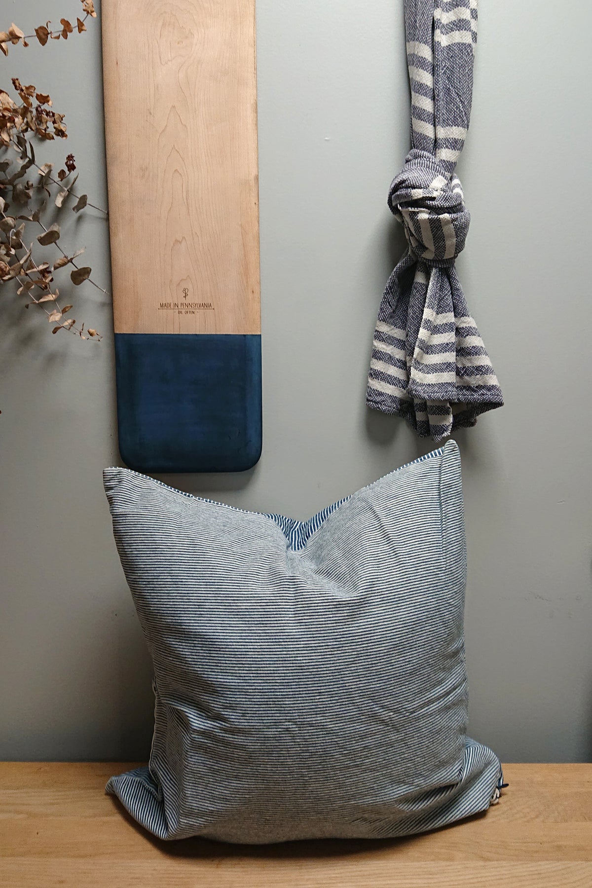 Indigo striped lumbar pillow with gray solid back and angled cushion view