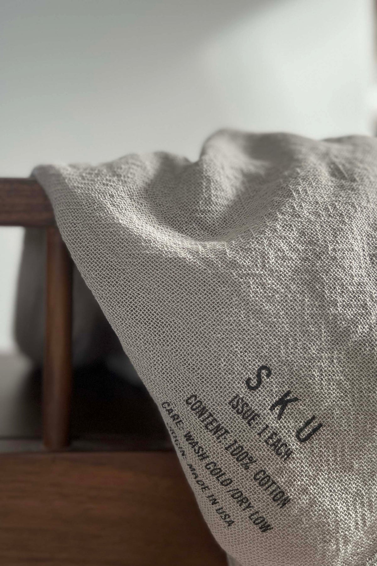 Tobacco cloth wrap throw, light gray textured fabric with printed label